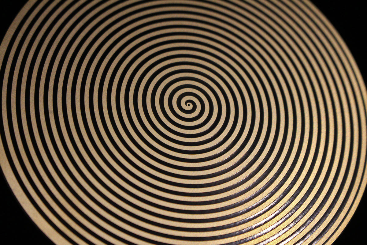 Close-up of a sacred spiral metallic healing disk