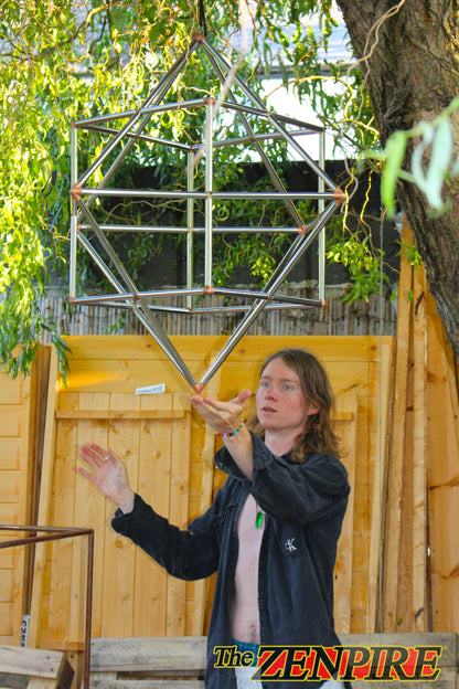 The King of The Zenpire man standing communing with his sacred geometric copper wire form of cube-otcahedron
