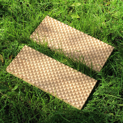 a beech wood spiked sadhu acupressure board laid out in grass