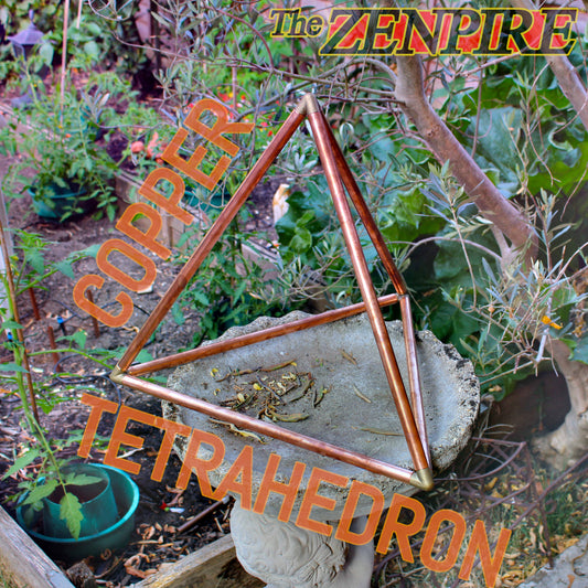 A copper metal tetrahedron garden sculpture for meditation displayed outdoors in a garden 