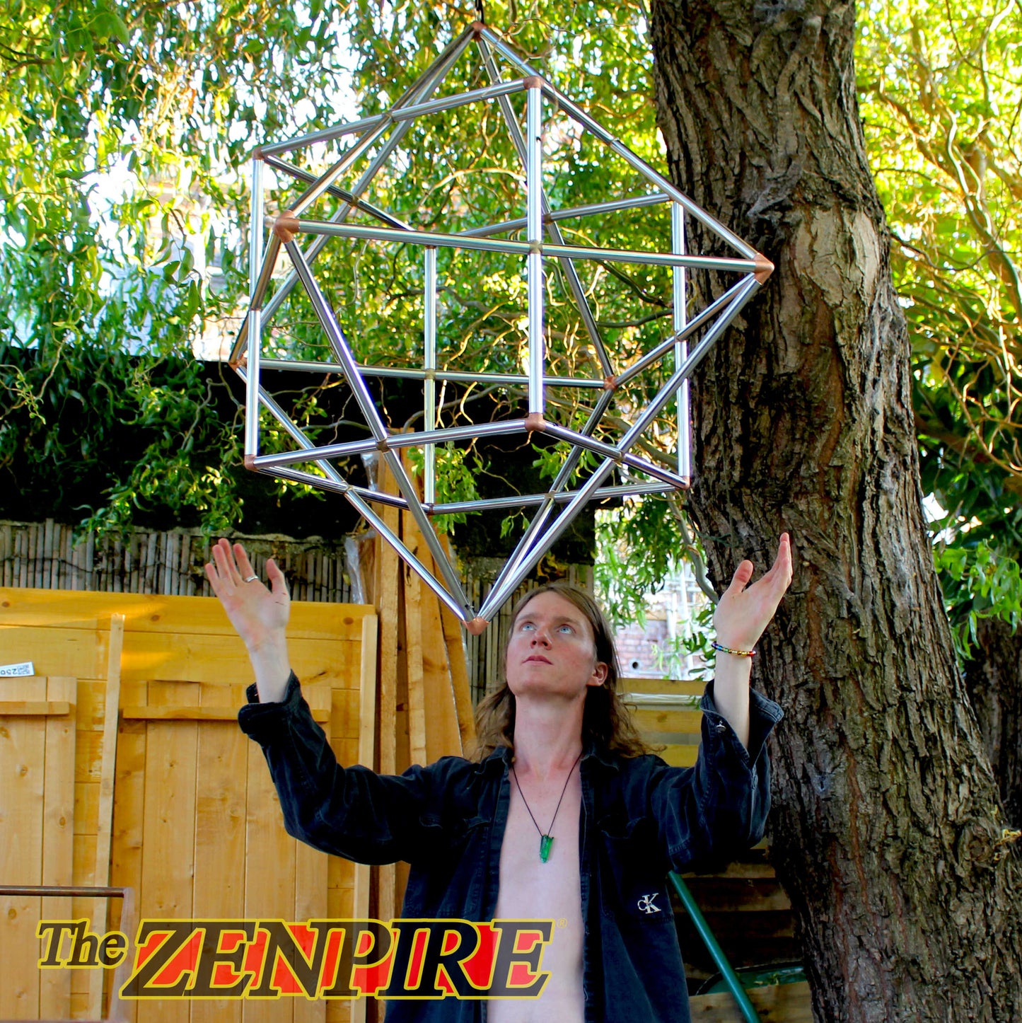 A person communing and connecting with a sacred geometric cube octahedron form made from copper pipes