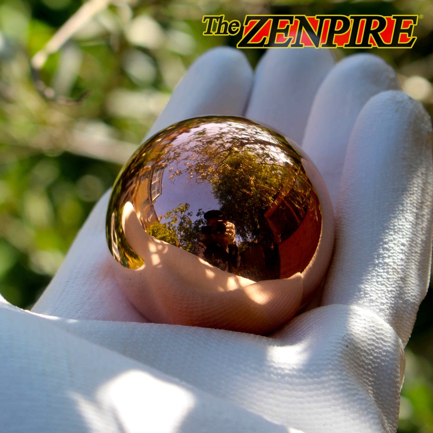 solid 50mm copper sphere being held for display in a gloved hand
