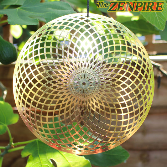 metallic brass healing disk in the shape of a torus or toroidal field hanging from a  tree