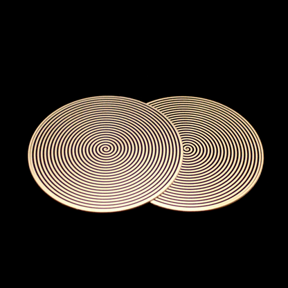 two metallic disk featuring a clockwise and counter-clockwise spiral pattern for elf healing
